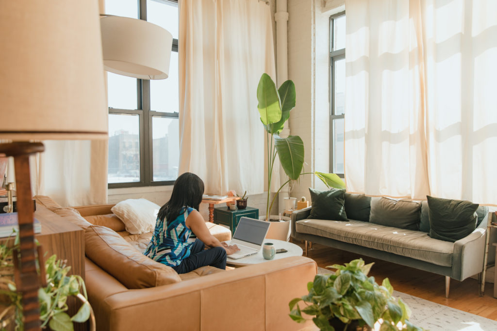 Woman sitting on a couch while using her laptop